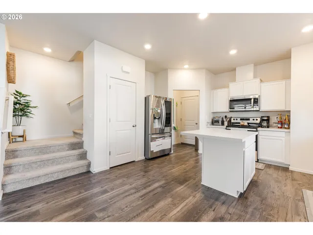a kitchen with a refrigerator and a stove top oven