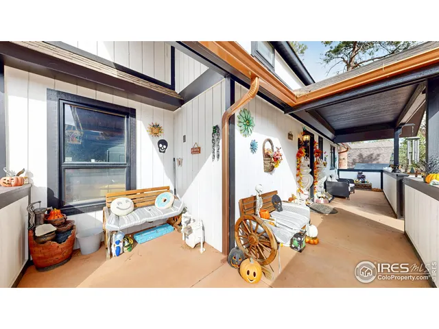a balcony with wooden floor table and chairs
