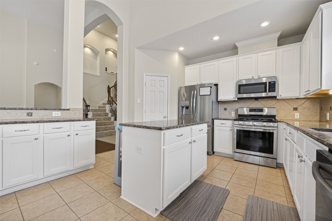 3219 Legends Mist Drive Spring, TX 77386 - Photo 16 of 50 a kitchen with granite countertop white cabinets and stainless steel appliances