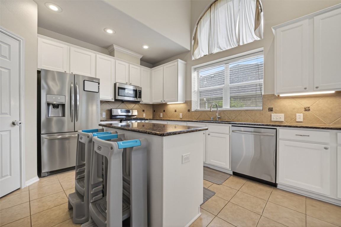 3219 Legends Mist Drive Spring, TX 77386 - Photo 17 of 50 a kitchen with granite countertop a refrigerator stove top oven and sink
