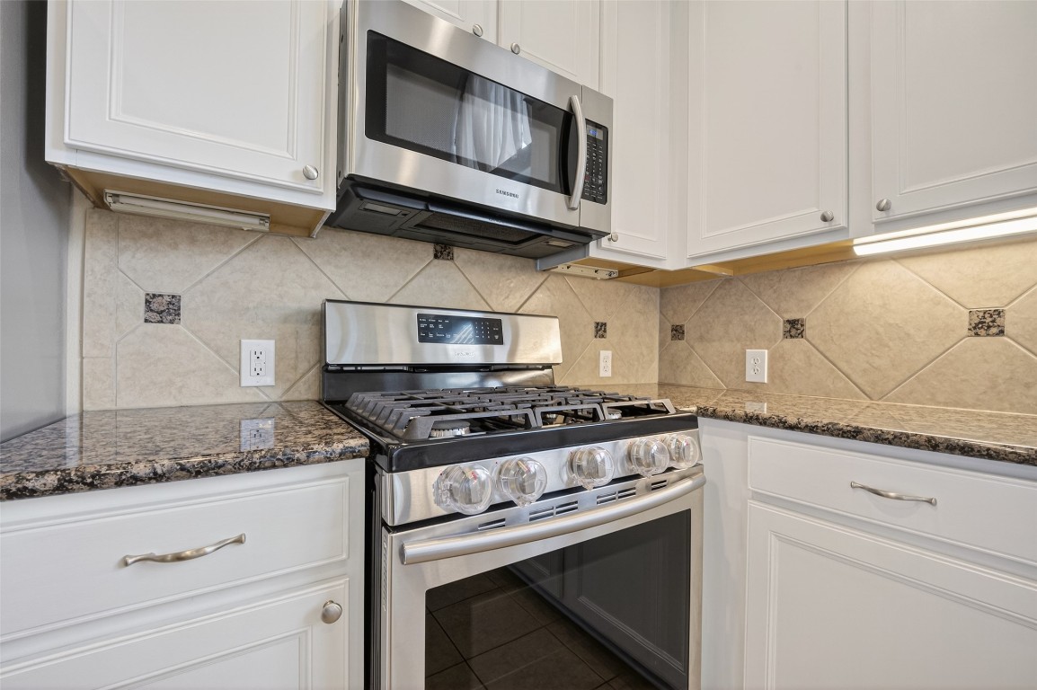 3219 Legends Mist Drive Spring, TX 77386 - Photo 20 of 50 a kitchen with stainless steel appliances granite countertop white cabinets and a stove top oven with granite countertops
