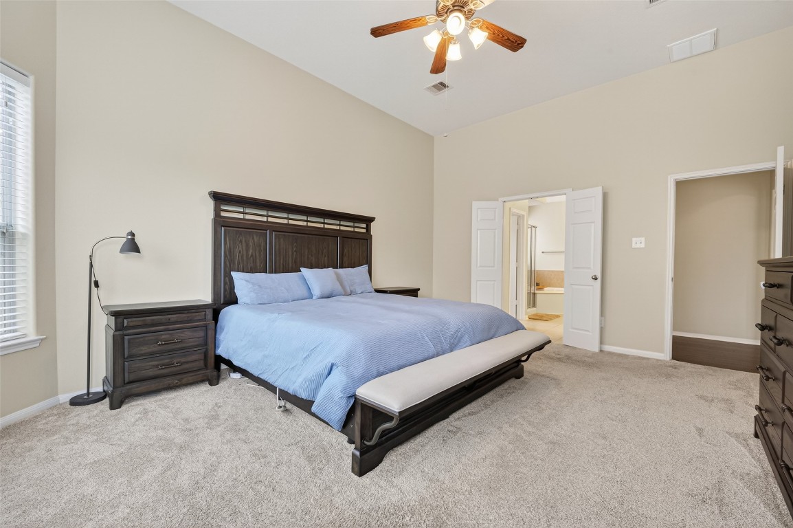 3219 Legends Mist Drive Spring, TX 77386 - Photo 28 of 50 a bedroom with a large bed and a chandelier
