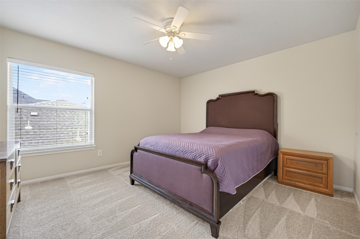 3219 Legends Mist Drive Spring, TX 77386 - Photo 42 of 50 a spacious bedroom with a bed and a chandelier
