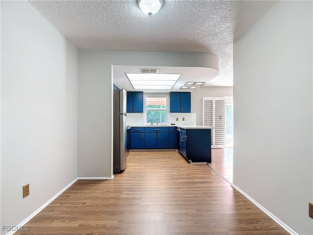 5946 Stringfellow Road St. James City, FL 33956 - Photo 14 of 50 a kitchen with kitchen island sink and wooden floor