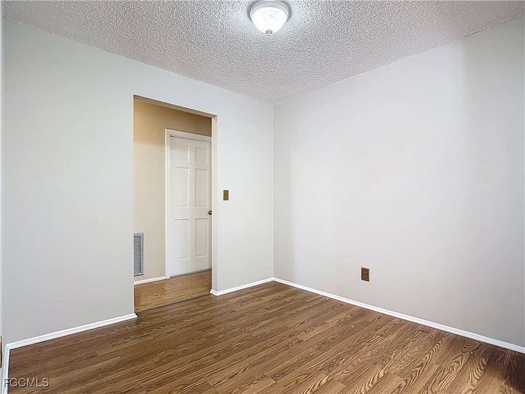 5946 Stringfellow Road St. James City, FL 33956 - Photo 15 of 50 a view of an empty room with wooden floor