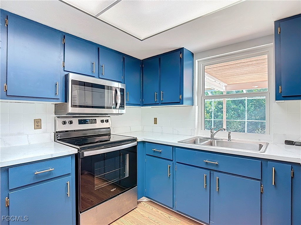 5946 Stringfellow Road St. James City, FL 33956 - Photo 17 of 50 a kitchen with a sink stove and microwave