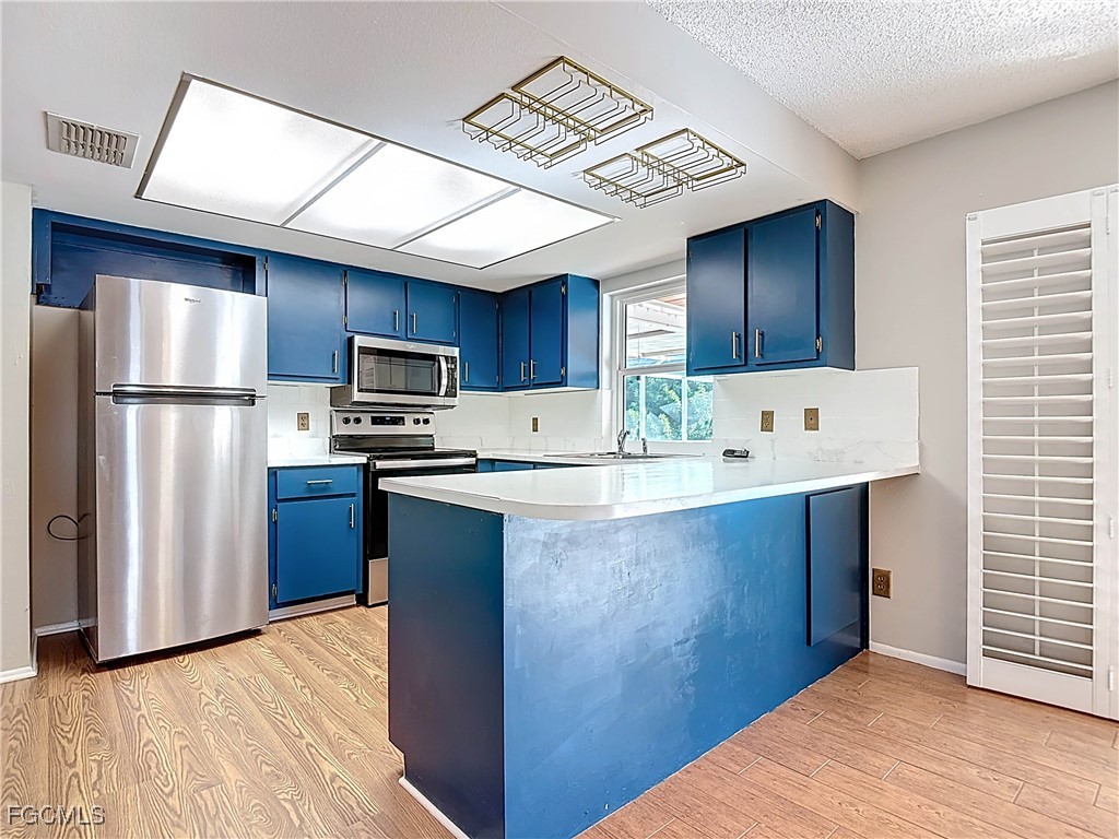 5946 Stringfellow Road St. James City, FL 33956 - Photo 19 of 50 a kitchen with stainless steel appliances granite countertop a refrigerator a sink dishwasher a stove with wooden cabinets