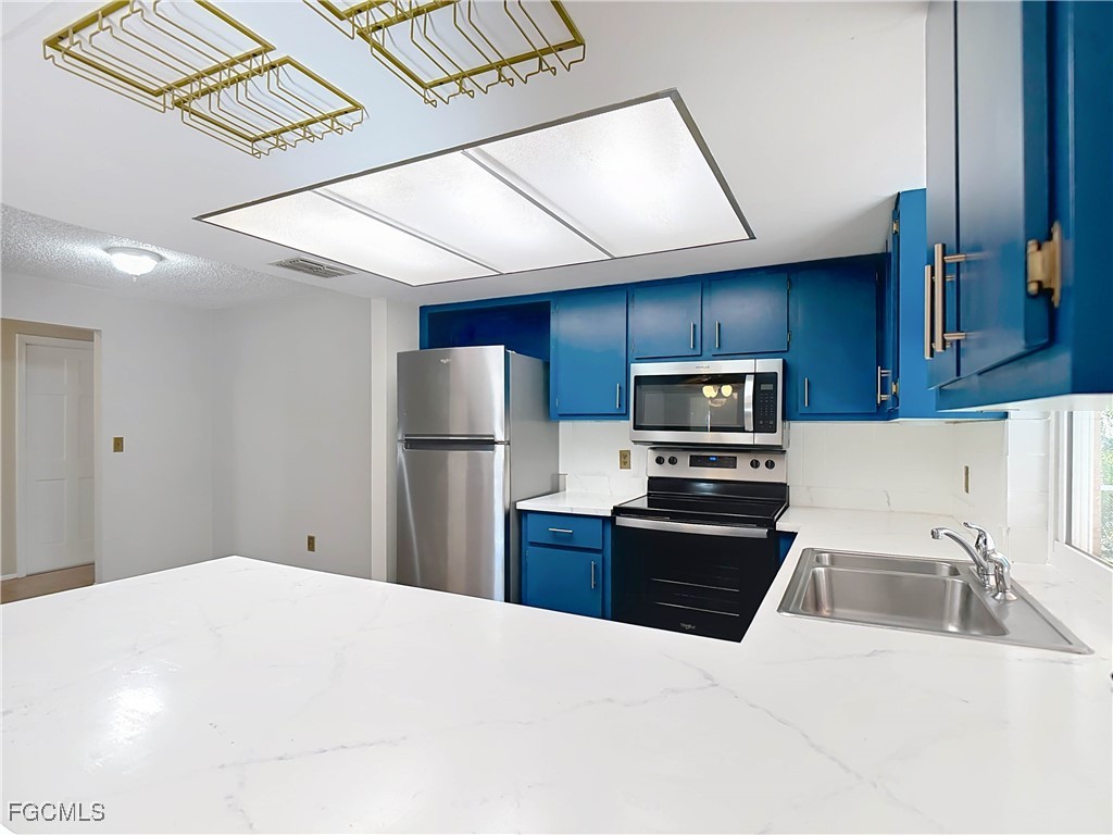 5946 Stringfellow Road St. James City, FL 33956 - Photo 20 of 50 a kitchen with refrigerator cabinets and stainless steel appliances