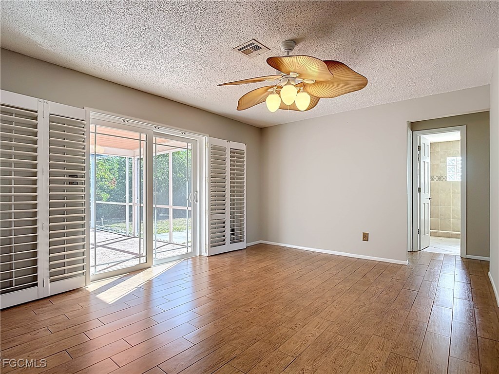 5946 Stringfellow Road St. James City, FL 33956 - Photo 21 of 50 an empty room with wooden floor and windows