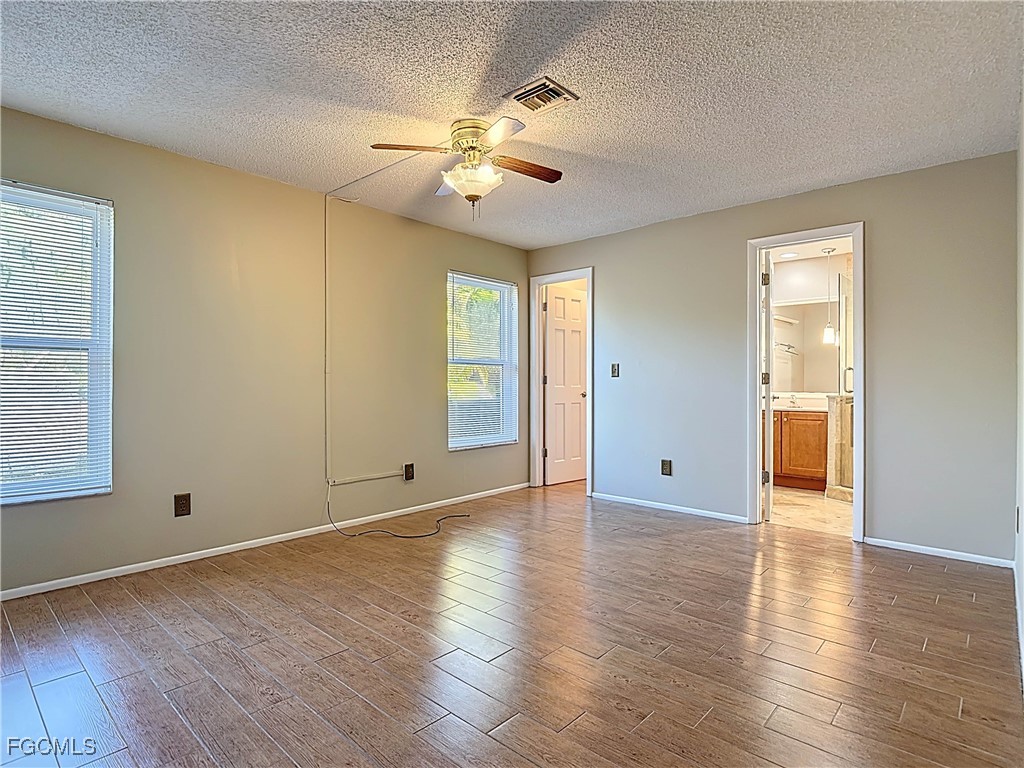 5946 Stringfellow Road St. James City, FL 33956 - Photo 27 of 50 an empty room with wooden floor and windows