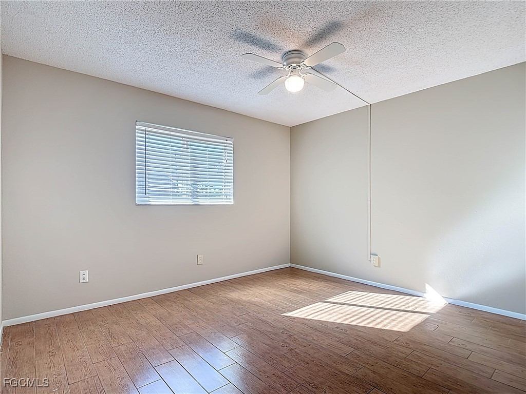 5946 Stringfellow Road St. James City, FL 33956 - Photo 34 of 50 an empty room with wooden floor and windows