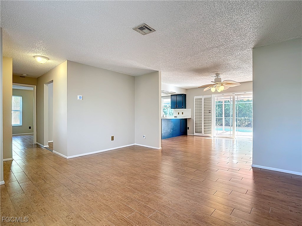 5946 Stringfellow Road St. James City, FL 33956 - Photo 10 of 50 a view of empty room with wooden floor and fireplace