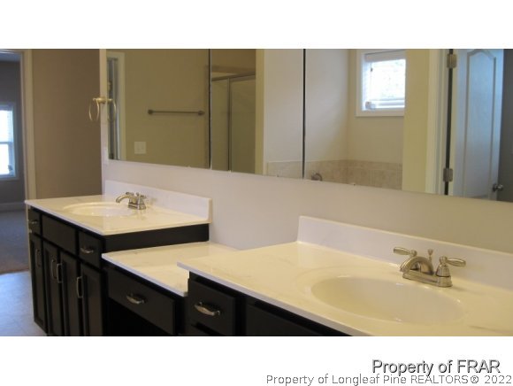 775 Sun Road Aberdeen, NC 28315 - Photo 12 of 17 a bathroom with a sink a mirror and a toilet