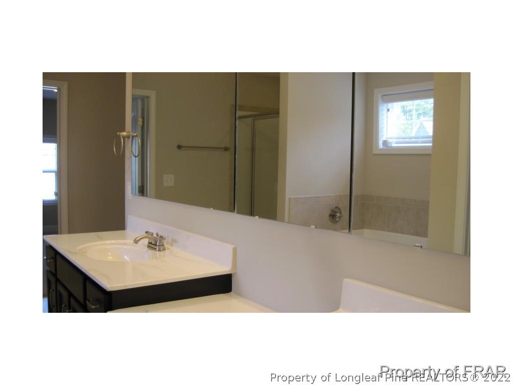 775 Sun Road Aberdeen, NC 28315 - Photo 13 of 17 a bathroom with a sink and a mirror