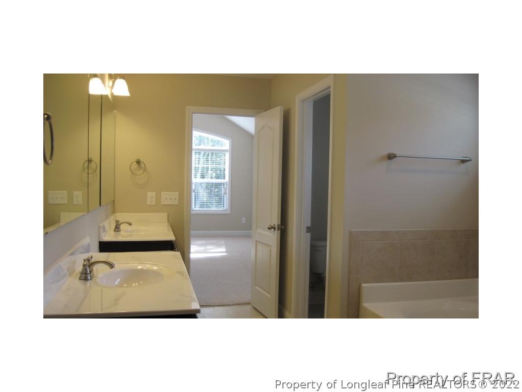 775 Sun Road Aberdeen, NC 28315 - Photo 15 of 17 a bathroom with a sink and a mirror
