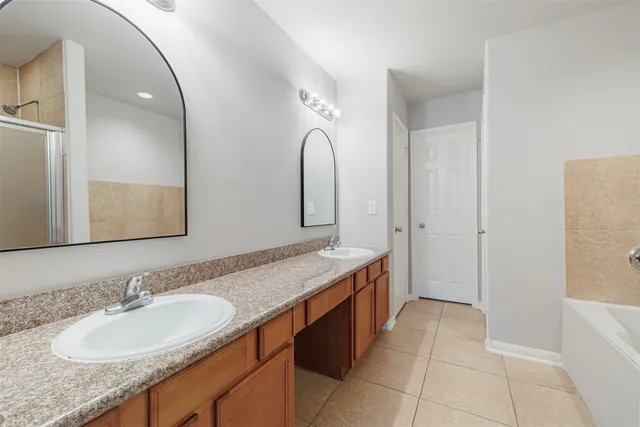 a spacious bathroom with a granite countertop sink and a mirror