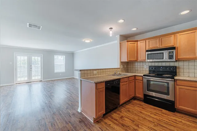 a kitchen with stainless steel appliances granite countertop a stove a sink and a refrigerator