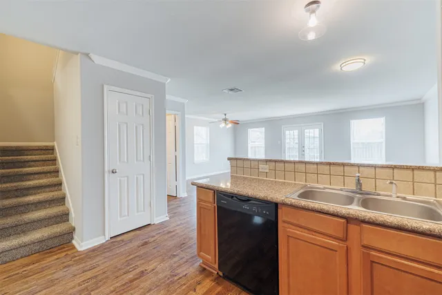 a kitchen with granite countertop a sink and a wooden floor
