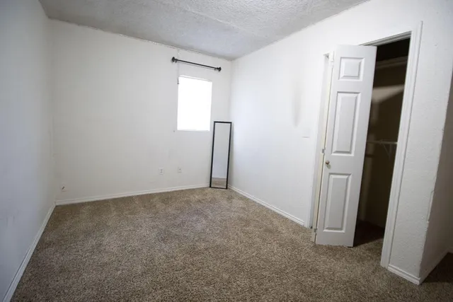 an empty room with closet and windows