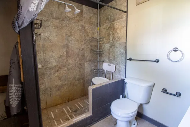 a white toilet sitting next to a bathroom sink and a shower