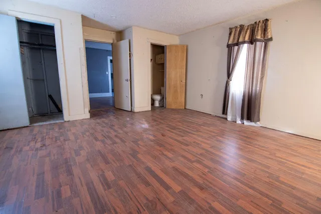 an empty room with wooden floor and closet