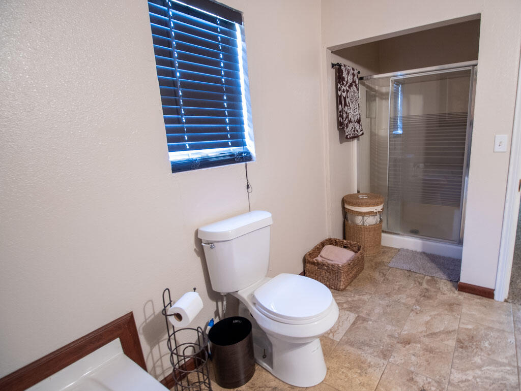 2609 County Road 7110 Lubbock, TX 79404 - Photo 7 of 29 a white toilet sitting next to a bathroom sink and vanity