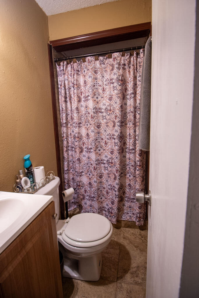2609 County Road 7110 Lubbock, TX 79404 - Photo 9 of 29 a bathroom with a toilet and a shower curtain