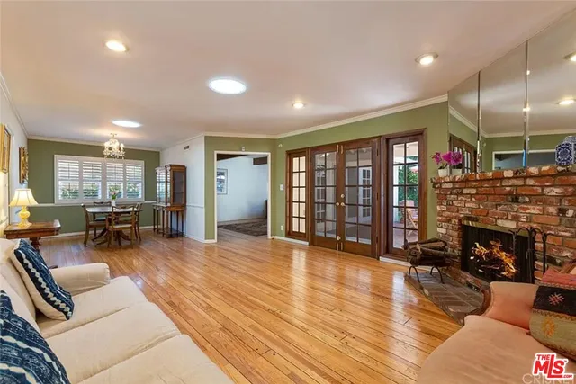 a living room with furniture a fireplace and a floor to ceiling window
