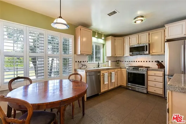 a kitchen with a stove a refrigerator and a dining table