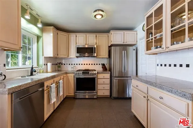 a kitchen with stainless steel appliances granite countertop a stove a sink and a refrigerator
