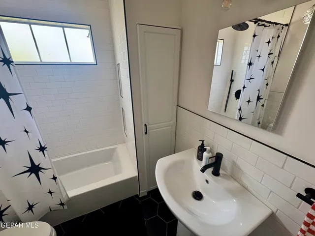 a bathroom with a sink a mirror and shower