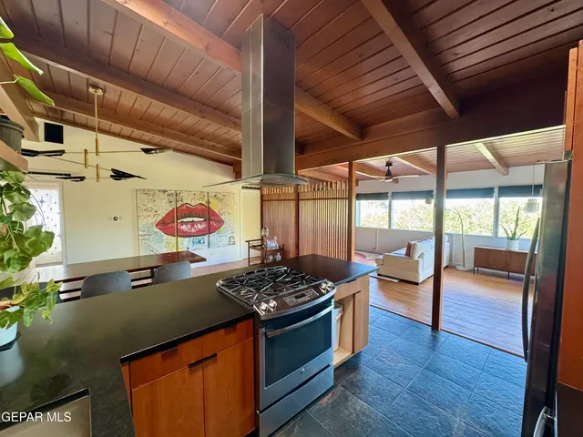 a kitchen with a stove a refrigerator and wooden floor