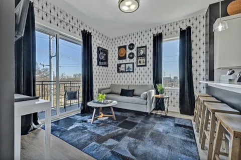 a living room with furniture a fireplace and a floor to ceiling window