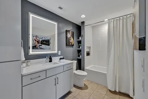 a bathroom with a double vanity sink toilet and shower