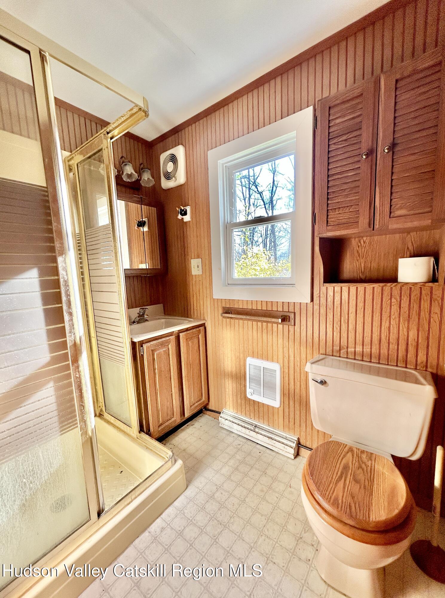 335 Tempaloni Road Ellenville, NY 12428 - Photo 15 of 26 a bathroom with a toilet a sink and mirror