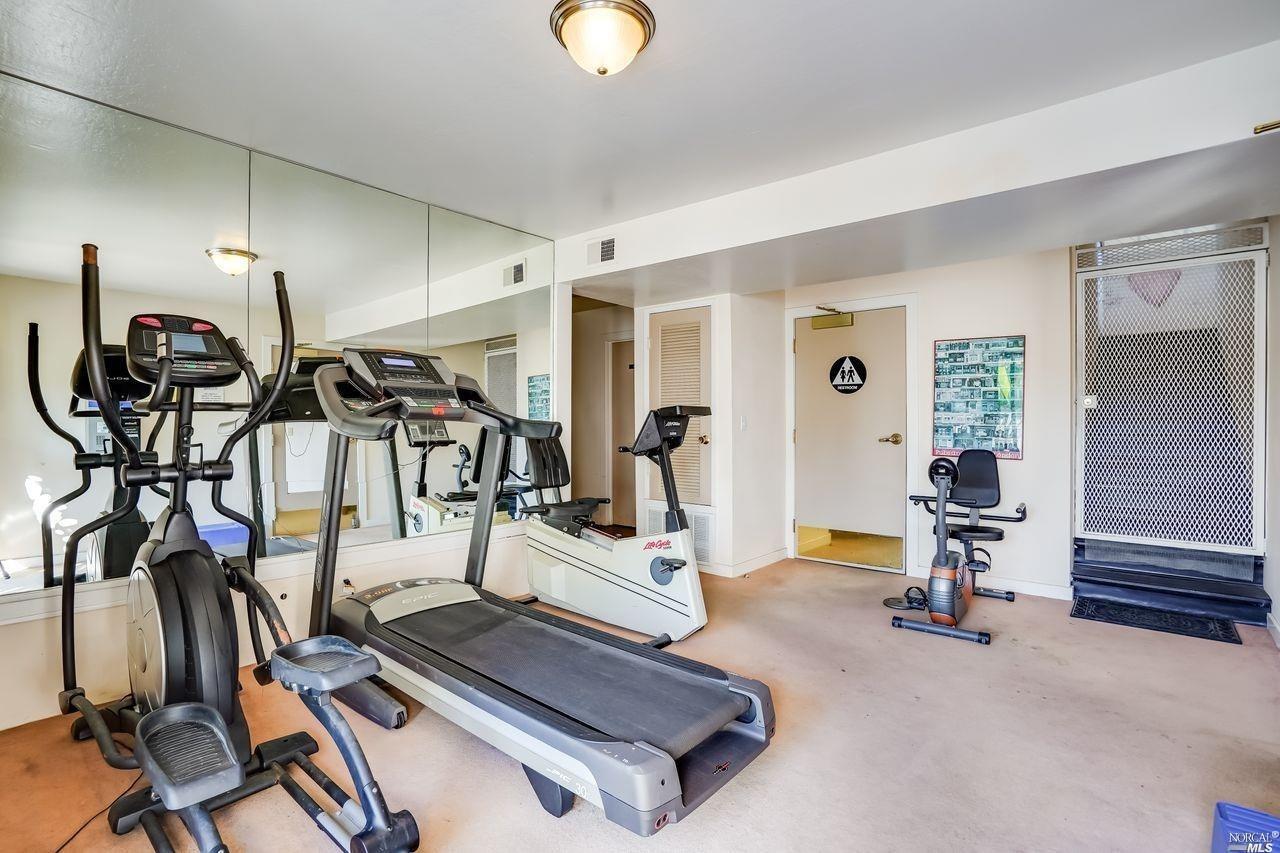 a room with gym equipment and view of living room