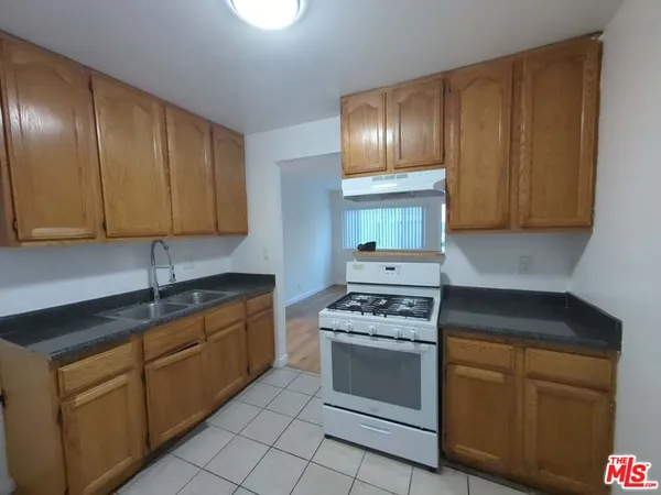 a kitchen with granite countertop stainless steel appliances stove top oven and cabinets