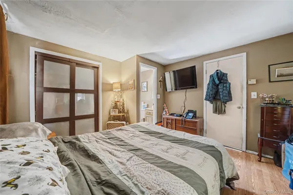 a bedroom with a large bed and a flat tv screen