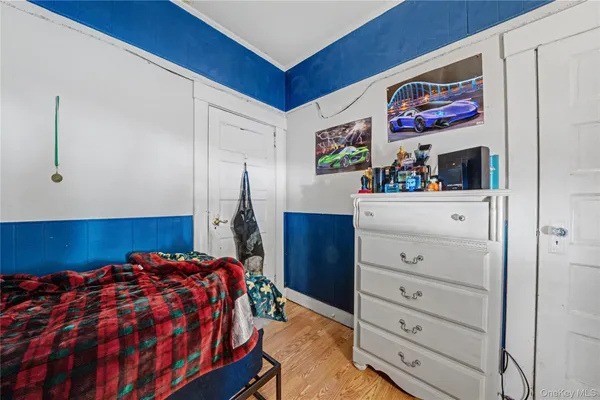 a bedroom with a bed and painting on the wall