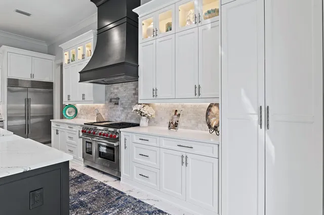 a kitchen with white cabinets and appliances