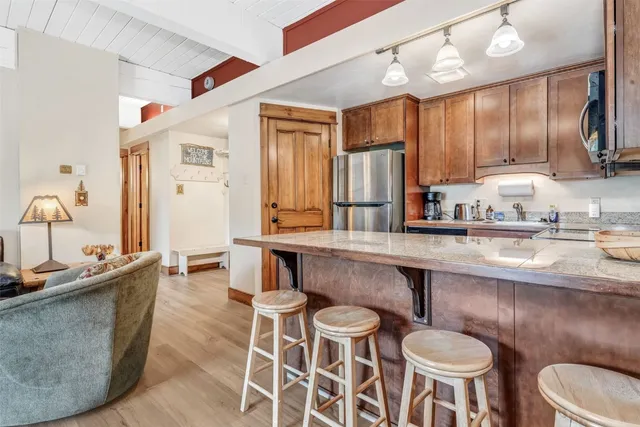 a kitchen with a dining table chairs sink and wooden floor