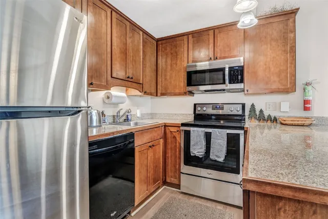 a kitchen with stainless steel appliances granite countertop a refrigerator sink and stove