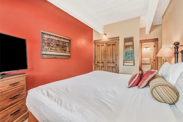 a bedroom with a bed and a flat screen tv