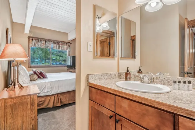 a en suite bathroom with a granite countertop sink and a mirror