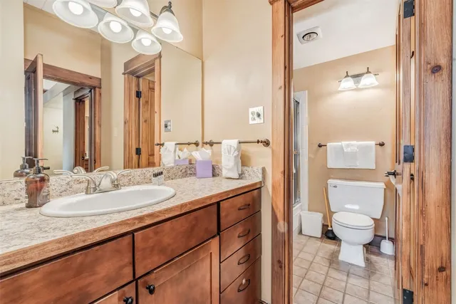 a spacious bathroom with a granite countertop sink mirror and a toilet