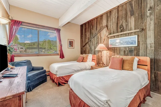 a bedroom with two beds and a large window