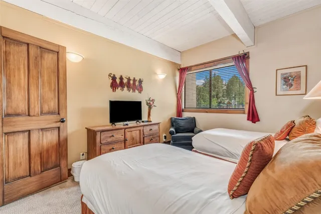 a bedroom with a large bed and a flat tv screen