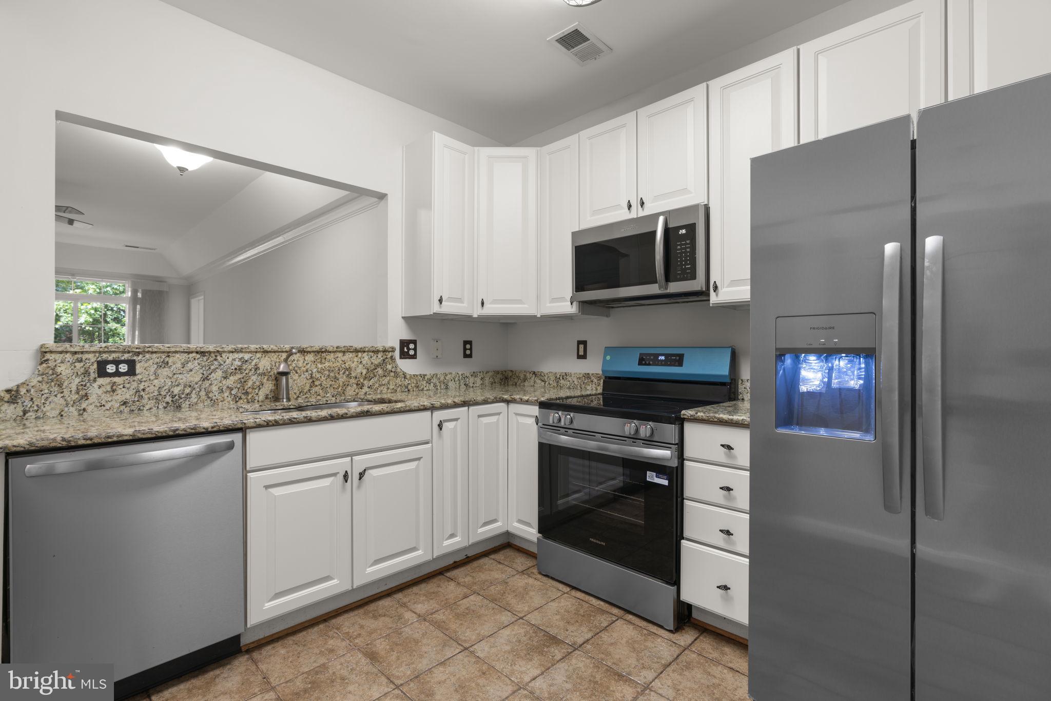 7315 Maplecrest Road, Unit 104 Elkridge, MD 21075 - Photo 19 of 58 a kitchen with stainless steel appliances granite countertop a refrigerator and a stove top oven
