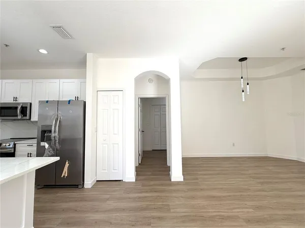 a view of a kitchen with wooden floor and a refrigerator