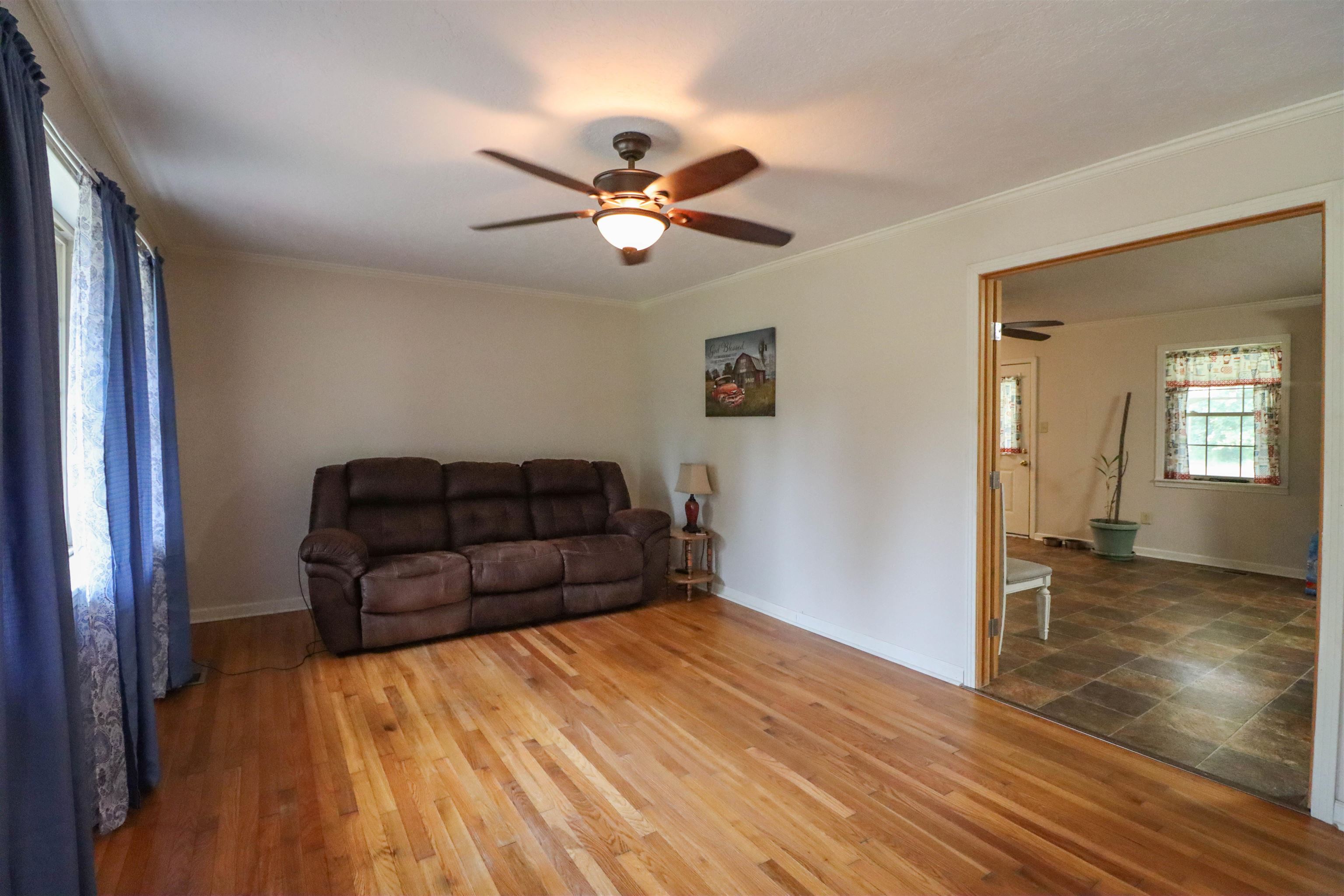 2143 Toulon Road Ripley, TN 38063 - Photo 6 of 39 Living area featuring crown molding, original hardwood flooring, and a ceiling fan